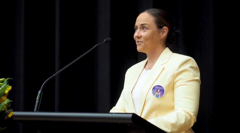 Alex Saundry (2010) speaking at the podium for IWD